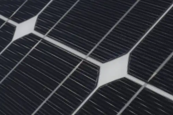 Close-up of dark blue solar cells and the white gaps between them