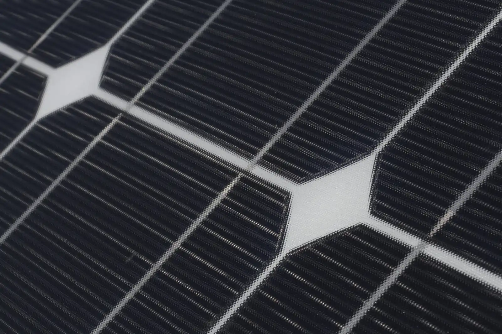 Close-up of dark blue solar cells and the white gaps between them